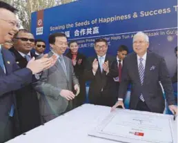  ??  ?? Najib receives applause after signing a plaque at Peacock Lake Park in Gu’an, that was designed with an advanced sewage water processing system.