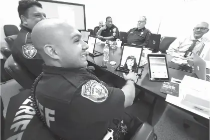  ?? Steve Gonzales photos/Houston Chronicle via AP ?? Harris County Sheriff’s Deputies Fred Lerma and Jose Gomez receive a call from Dr. Elizabeth Truong during a a pilot test of a telepsych program training session on Dec. 12 in Houston. The new telepsychi­atry pilot program will arm deputies with tablets...