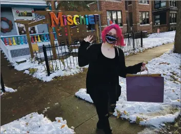  ?? PHOTOS BY DAN MARSHALL ?? Abby Marshall delivers a package for curbside pickup outside the Mischief Toy Store in St. Paul, Minn., on Nov. 11.