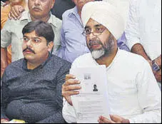  ?? SAMEER SEHGAL/HT ?? Finance minister Manpreet Badal showing the BJP candidate’s nomination papers for the Gurdaspur LS bypoll, at a press conference in Amritsar on Wednesday.