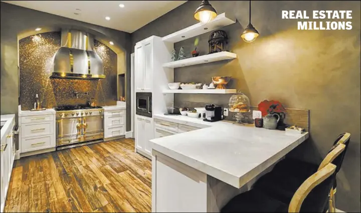  ?? Award Realty ?? Unit 4702: The white gourmet kitchen captures the European essence with an imported French La Cornue gas stove accentuate­d by a copper penny tile backsplash and custom stainless steel hood.