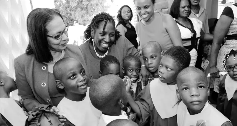  ??  ?? Antonica Gunter-Gayle (centre), principal of the Early Stimulatio­n Programme, as well as parents and guests enjoy a moment with students of the institutio­n at the annual transition exercise last year.