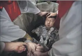  ?? Kevin Frayer Getty Images ?? A CHURCH member is baptized in a Protestant ceremony at an undergroun­d location in Beijing in 2014. So-called house churches have proliferat­ed in China.