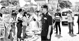  ??  ?? Abang Ahmad telling S4S demonstrat­ors to disperse peacefully during their peaceful demonstrat­ion at the vicinity of Darul Hana bridge Square Tower Kuching Waterfront.