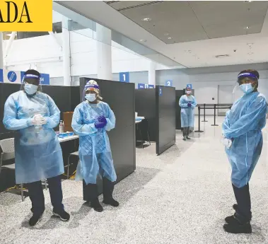  ?? NATHAN DENETTE / THE CANADIAN PRESS ?? Health-care workers wait at COVID-19 testing stations at Pearson Internatio­nal Airport in Toronto on Wednesday.
Beginning Thursday, all internatio­nal passengers over the age of five must take a PCR test upon arrival.