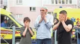  ?? AFP VIA GETTY IMAGES ?? People pray Tuesday at a memorial for a shooting in Kazan. At least nine people, most of them children, were killed and 21 were injured.