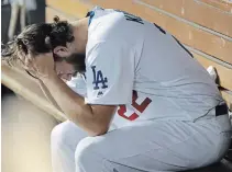  ?? MARCIO JOSE SANCHEZ THE ASSOCIATED PRESS ?? Clayton Kershaw sits in the dugout after giving up back-to-back home runs to the Washington Nationals in the eighth inning on Wednesday in L.A. The Nationals won, 7-3 in 10 innings.