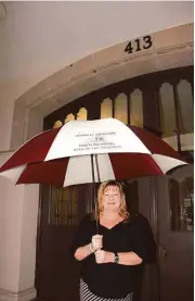  ?? Jimmy Loyd / For the Chronicle ?? Principal Connie Berger holds a John H. Reagan umbrella on the rainy last day of school. Next year the school will be renamed Heights High School.