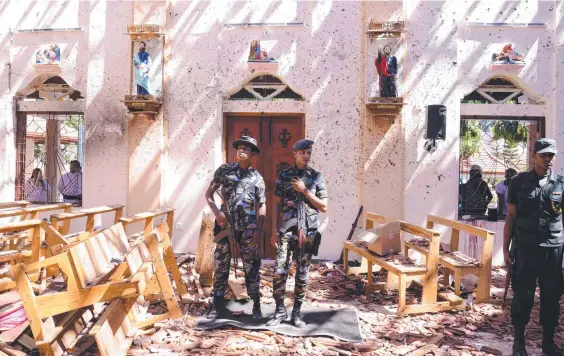  ?? Picture: AFP ?? Sri Lankan soldiers inside the St Sebastian's Church at Katuwapiti­ya in Negombo following a bomb blast during the Easter service that killed tens of people. A series of eight devastatin­g bomb blasts ripped through high-end hotels and churches holding Easter services