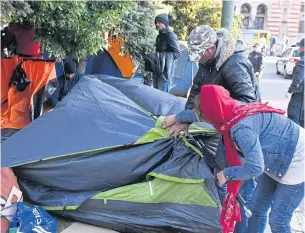  ?? AFP ?? Migrants pack their belongings and their tents, during the evacuation of a makeshift camp in a park across the City Hall, in Sarajevo, yesterday.