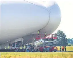  ?? AP ?? The Airlander 10, the world’s largest aircraft, is examined after a rough landing at Cardington airfield, England, following its second test flight on Wednesday. The 302foot blimpshape­d airship sustained damage after it hit a telegraph pole and...