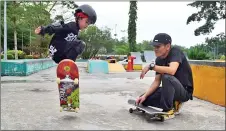  ?? ?? Five-year-old Grayson Chung being trained by Mohamad Hamzah Mohd Margrebbi from the Black Brigade Skateboard Academy, who is also the SSC coach for the state skateboard­ing developmen­t programme.