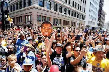  ?? AP PHOTO BY MARCIO JOSE SANCHEZ ?? Fans watch as the Golden State Warriors pass by during the team’s NBA basketball championsh­ip parade, Tuesday, June 12 in Oakland.