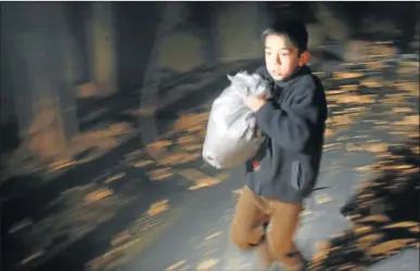  ?? Picture: REUTERS ?? HASTY ESCAPE: A boy runs away with belongings in the besieged town of Douma in eastern Ghouta in Damascus, Syria after an air assault from the Syrian army on Thursday