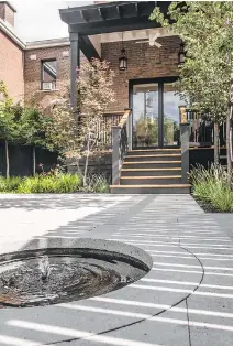  ??  ?? Glass doors allow residents ready access to their backyard oasis, complete with its Zen-like water feature.