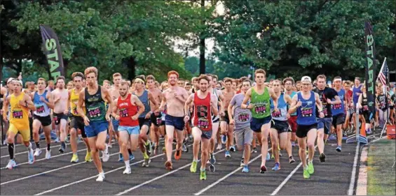  ?? PAUL DICICCO — THE NEWS-HERALD ?? Runners at the start of the Friday Night Lights 5K race at Mentor’s Jerome T. Osborne Stadium.