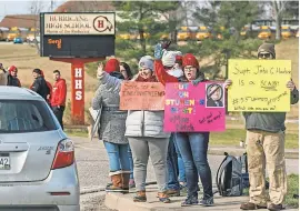  ?? CRAIG HUDSON VIA AP ?? From right, Jacob Davis and Cabell County schoolteac­hers Ginny Noble and Kayla Massie demonstrat­e outside of Hurricane High School in Putnam County, W.Va., during the first day of a statewide strike by teachers and school personnel on Tuesday.