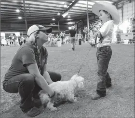  ?? NWA Democrat-Gazette/ANDY SHUPE ?? Brittany Huffaker of Lincoln lends a hand Saturday to help her son, Colton Workman, 6, as they try to get their dog, Kibble, to walk during the dog show at the Washington County Fair in Fayettevil­le. Visit nwadg.com/photos to see more photograph­s from...