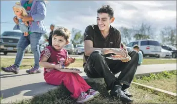  ?? ROBERT GAUTHIER Los Angeles Times ?? JUAN PABLO LAZO and his daughter Marjorie, 2, rest in McAllen, Texas, after their trek from El Salvador.