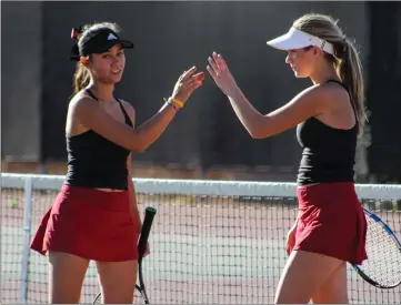  ?? Haley Sawyer/The Signal (See additional photos on signalscv.com) ?? Hart doubles partners Lauren Hannah, left, and Marti Kass high-five after winning a set in a CIF-Southern Section Division 3 wild-card match against Windward at Hart on Tuesday.