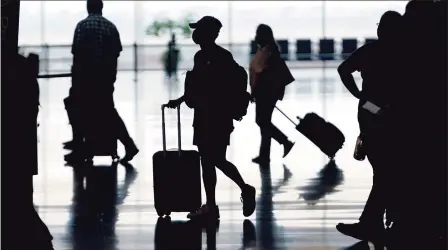  ?? Associated Press ?? Travelers move through Salt Lake City Internatio­nal Airport earlier this month. A COVID-19 resurgence this summer has caused consumers to turn cautious, while investors trim their investment­s in a travel sector still struggling to recover.