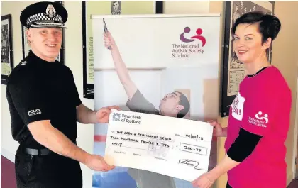  ??  ?? Building blocks Divisonal Commander Gordon Crossan hands over the cheque to Susan Thomson