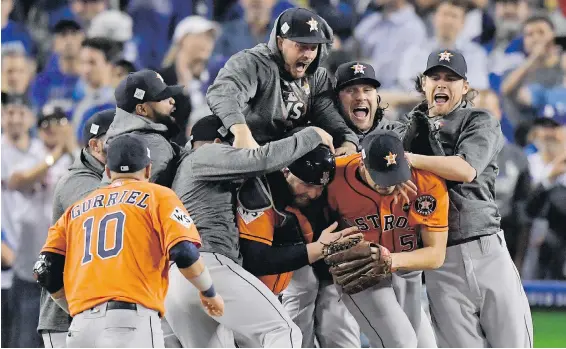  ??  ?? Houston Astros players pour onto the field to celebrate the franchise’s first World Series title after the final Dodgers out Wednesday night in Los Angeles.