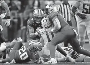  ?? Andy Nelson Associated Press ?? OREGON RUNNING BACK Bucky Irving (0) is stopped cold by a trio of Washington defenders led by Asa Turner (20), Alex Cook, middle, and Cam Bright during the first half.