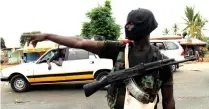  ??  ?? A mutinying soldier stands alert at a checkpoint in Bouake, Ivory Coast, on Monday. (Reuters)