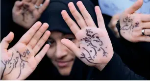  ?? AFP ?? Iranian girls take part in a rally outside the former US embassy in Tehran on Sunday, marking the anniversar­y of its storming by student protesters that triggered a hostage crisis in 1979. Farsi writing on their palms praises the supreme leader Ayatollah Ali Khamenei. Thousands joined rallies in Tehran and other cities while carrying placards that mocked President Donald Trump. —