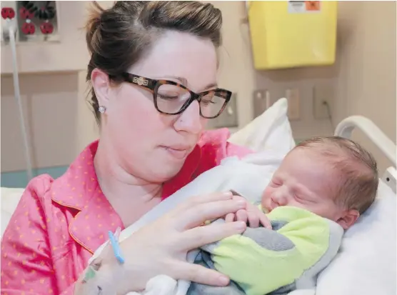  ?? Gavin Young/Calgary Herald ?? Valentene Warholik holds her newborn son Micah at the Foothills Hospital on New Year’s Day. Micah was born at 12:03 a.m., making him the 2014 New Year’s baby for Calgary.