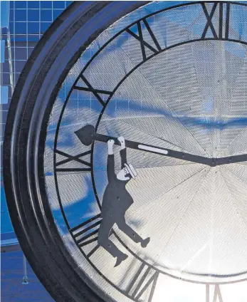  ?? FOTO: DPA ?? So wie diese Figur würden viele gerne einmal den Zeiger der Uhr anhalten. Der Eindruck, dass die Zeit rast, hat damit zu tun, dass zu viel auf einmal erledigt werden soll.