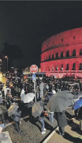  ??  ?? 0 People gather for a ceremony at the Colosseum in Rome, illuminate­d in red light and reading “Aid to the Church that Suffers,” drawing attention to the persecutio­n of Christians around the world