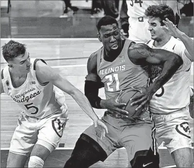  ?? MORRY GASH/AP ?? Illinois Kofi Cockburn (21) tries to get past Wisconsin’s Tyler Wahl (5) and Nate Reuvers during the first half Saturday in Madison, Wis. Cockburn led the Illini with 19 points in a 74-69 victory.