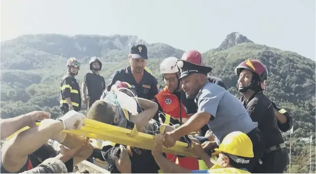  ??  ?? 0 Rescuers pass a stretcher with one of three brothers saved from their home, demolished during an earthquake which struck the Italian resort island of Ischia