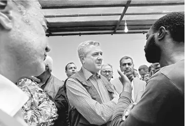  ??  ?? Grandi speaks with a migrant as he visits the Tripoli branch of the Anti-Illegal Immigratio­n Authority. — Reuters photo