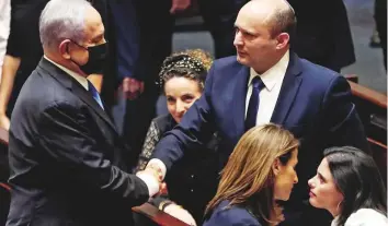  ?? Reuters ?? Netanyahu and Bennett shake hands following the vote on the new coalition at the Knesset in Jerusalem last night. Bennett is Israel’s first Orthodox Jewish prime minister.