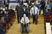  ??  ?? Henry County deputy Ralph Sidwell “Sid” Callaway, who was wounded in the gunfire, sits in a wheelchair during the funeral service for Chase Maddox.