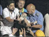  ??  ?? Rescuers pull out seven-month boy Pasquale from the rubble of a collapsed building in Casamiccio­la, on the island of Ischia, near Naples, Italy, a day after a 4.0-magnitude quake hit the Italian resort island on Tuesday.