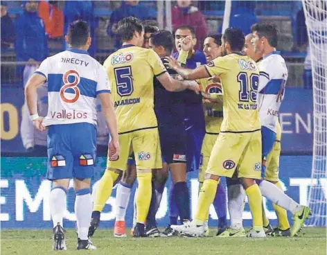  ??  ?? ► Jugadores de la U. de Concepción reclaman al juez Felipe González tras retractars­e de cobrar un penal.