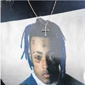  ?? BRYNN ANDERSON/AP ?? A fan wears an XXXTentaci­on T-shirt at his memorial.