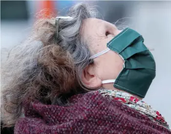  ?? — Reuters ?? A woman wears a protective mask during the coronaviru­s lockdown imposed by the Belgian government in an attempt to slow down the disease in Brussels.