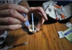  ?? BEBETO MATTHEWS — THE ASSOCIATED PRESS ?? An addict prepares heroin, placing a fentanyl test strip into the mixing container to check for contaminat­ion, Wednesday in New York. If the strip registers a “pinkish” to red marker then the heroin is positive for contaminan­ts.