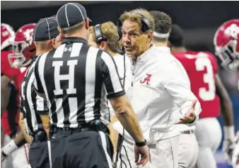  ?? THE ASSOCIATED PRESS ?? Alabama’s Nick Saban speaks to an official during the Crimson Tide’s season-opening win against Florida State this past Saturday night. On Wednesday, Saban said coaching has never been about the money for him.