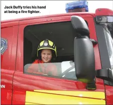  ??  ?? Jack Duffy tries his hand at being a fire fighter.