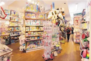  ?? RICHARD DREW/ASSOCIATED PRESS ?? A customer browses the aisles of Mary Arnold Toys in Manhattan. Mary Arnold, a nearly 90-year-old store, is thriving along with many other small and independen­t toy stores, even as Toys R Us is going out of business and more consumers shop online.