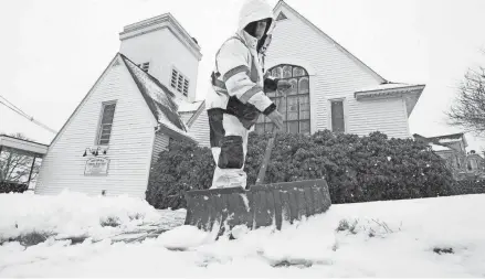  ?? STEVEN SENNE/AP ?? Worker Bayron Barrientos shovels snow off a path Tuesday in Norwood, Mass. As much as 7 or 8 inches of snow blanketed some communitie­s in the Northeast by Tuesday morning.