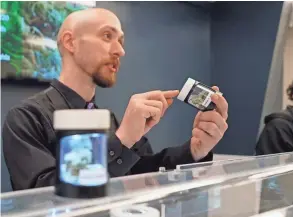  ??  ?? A clerk at the Cannabaska marijuana store in Anchorage, Alaska, discusses the particular­s of a strain of cannabis with a customer.