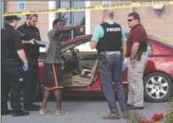  ?? The Sentinel-Record/Mark Gregory ?? SUSPECT: Emergency medical personnel and Hot Springs police speak to a man identified as Demarion Banks, 25, of Hot Springs, who reportedly drove to the Hot Springs Police Department in a bullet-riddled car minutes after a shooting erupted at Tire Express, 635 E. Grand Ave.