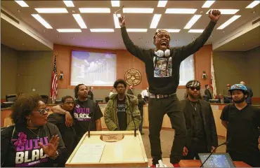  ?? RICH PEDRONCELL­I/AP ?? On March 27, 2018, Stevante Clark stands on a desk as he shouts the name of his brother Stephon Clark, who was fatally shot by police a week earlier, during a meeting of the Sacramento City Council. The shooting death of Stephon Clark helped spur the passage of two police use-of-force laws to take effect in 2020.